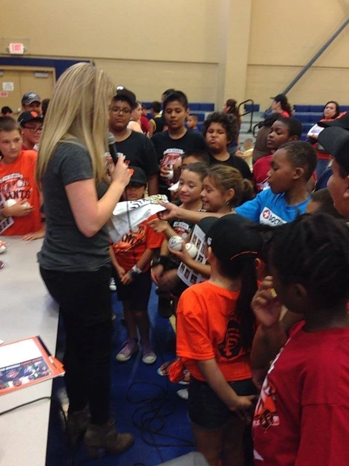 Libby Mays speaking with Junior Giants participants at an event