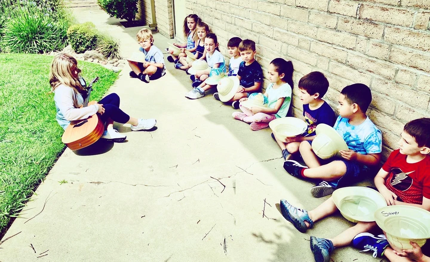 Libby Mays leading children during a local school music day activity